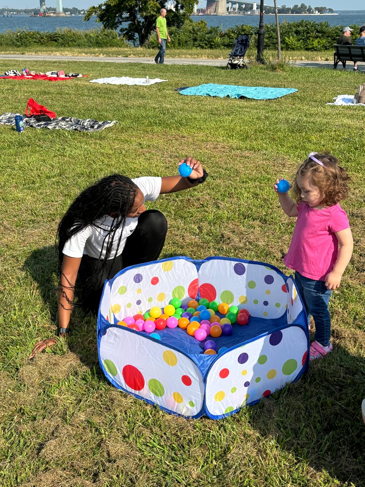 Child playing with colorful balls at outdoor playgroup
